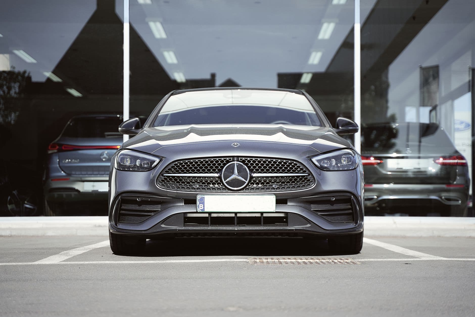 Front view of a sleek gray Mercedes-Benz sports car parked at an auto dealership.