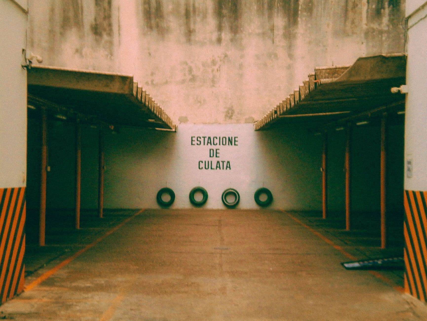 Empty parking area with Spanish signage and worn industrial texture in Rosario, Argentina.