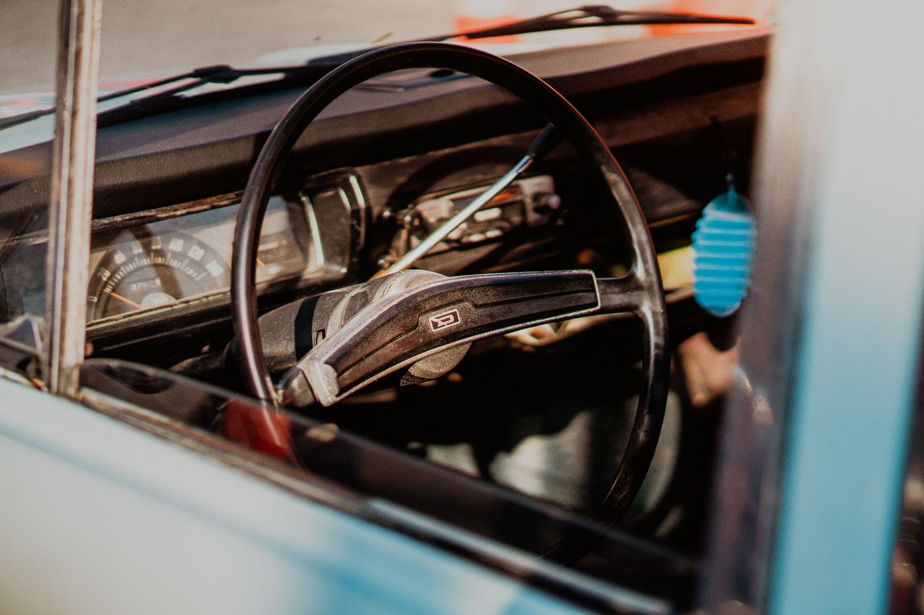 Close-up of a vintage car interior featuring a classic steering wheel and dashboard.