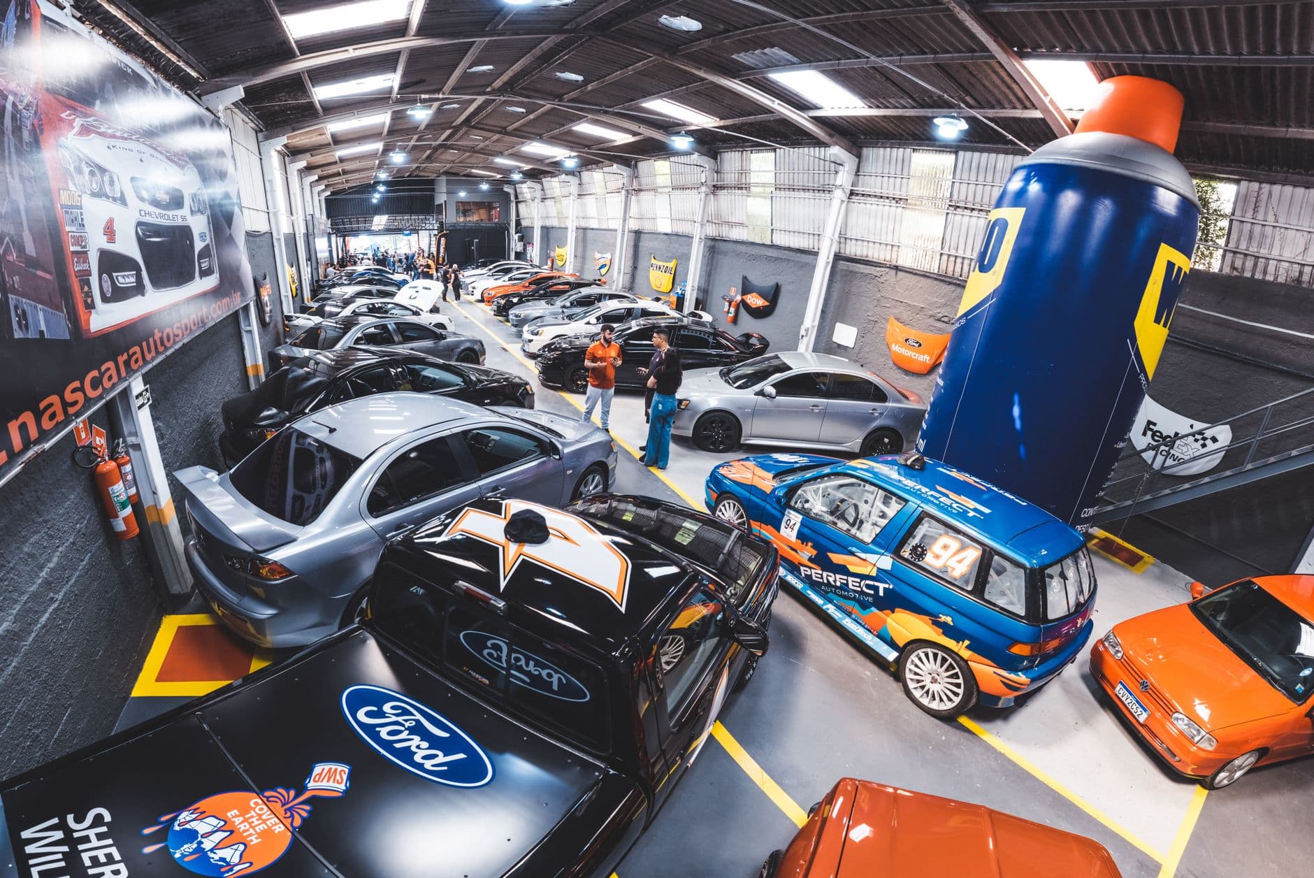 Indoor automotive showroom with classic cars on display, capturing vibrant colors and exciting atmosphere.