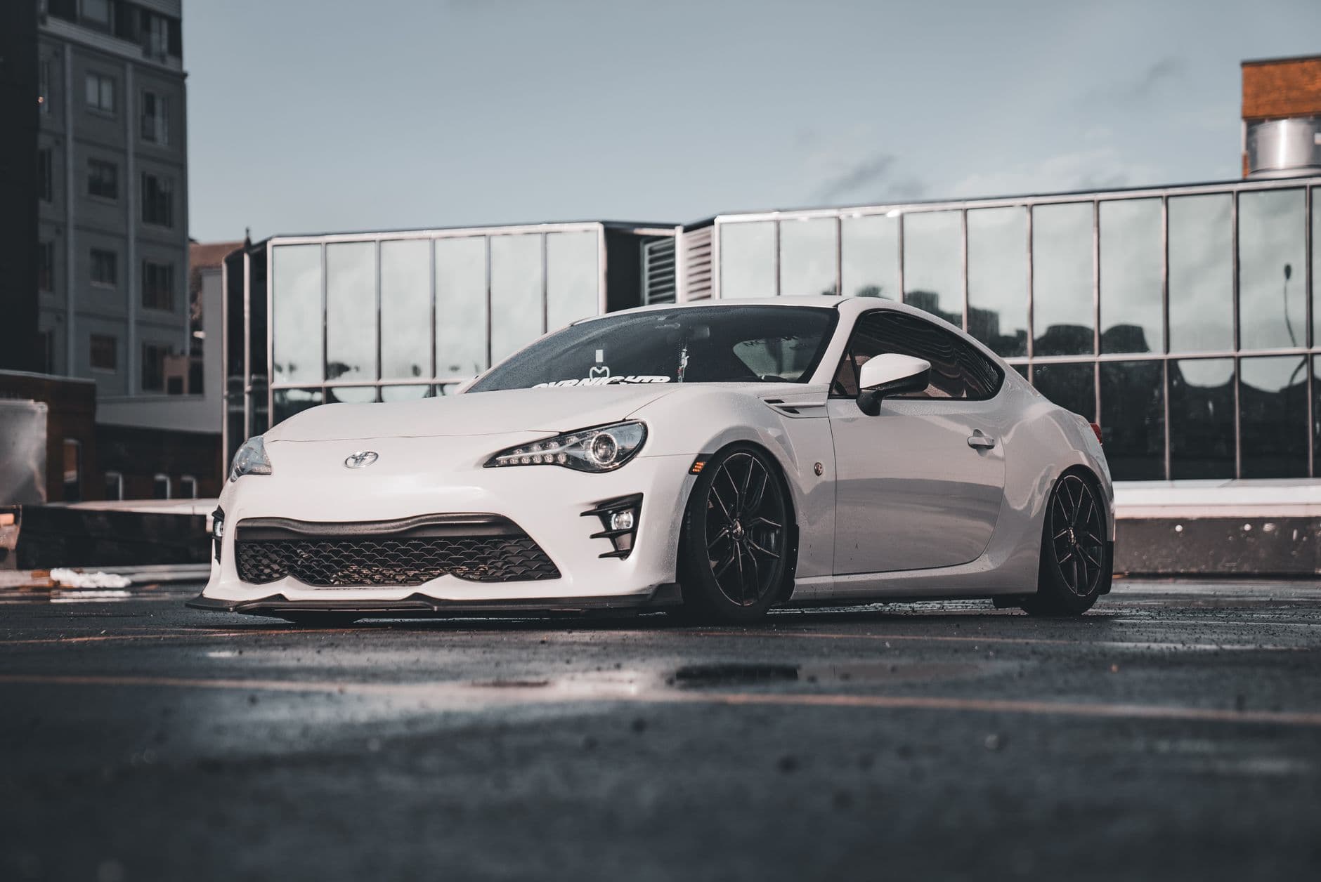 A sleek white sports car parked in an urban environment, showcasing modern automotive design.