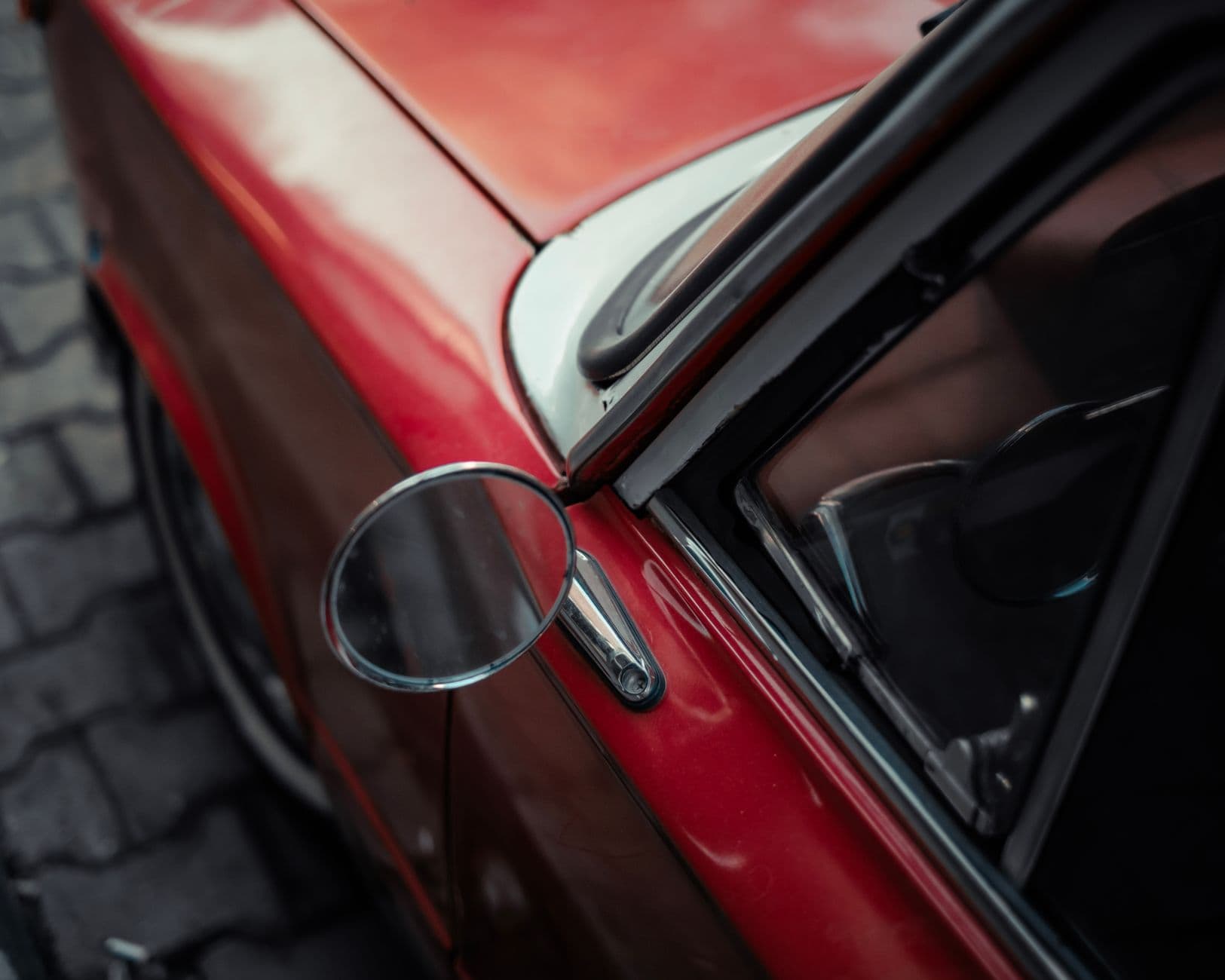 Close-up of a vintage red car in an Istanbul street showing classic design details.