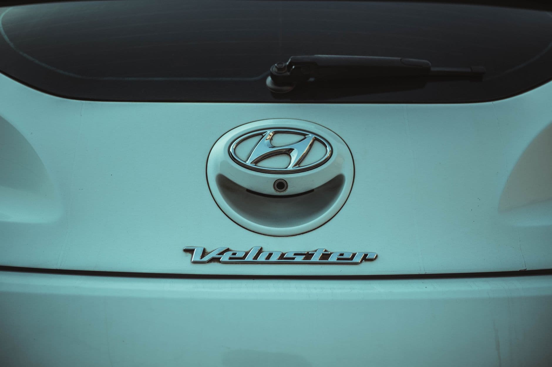 Detailed shot of the Hyundai Veloster rear emblem. Perfect for automotive enthusiasts.