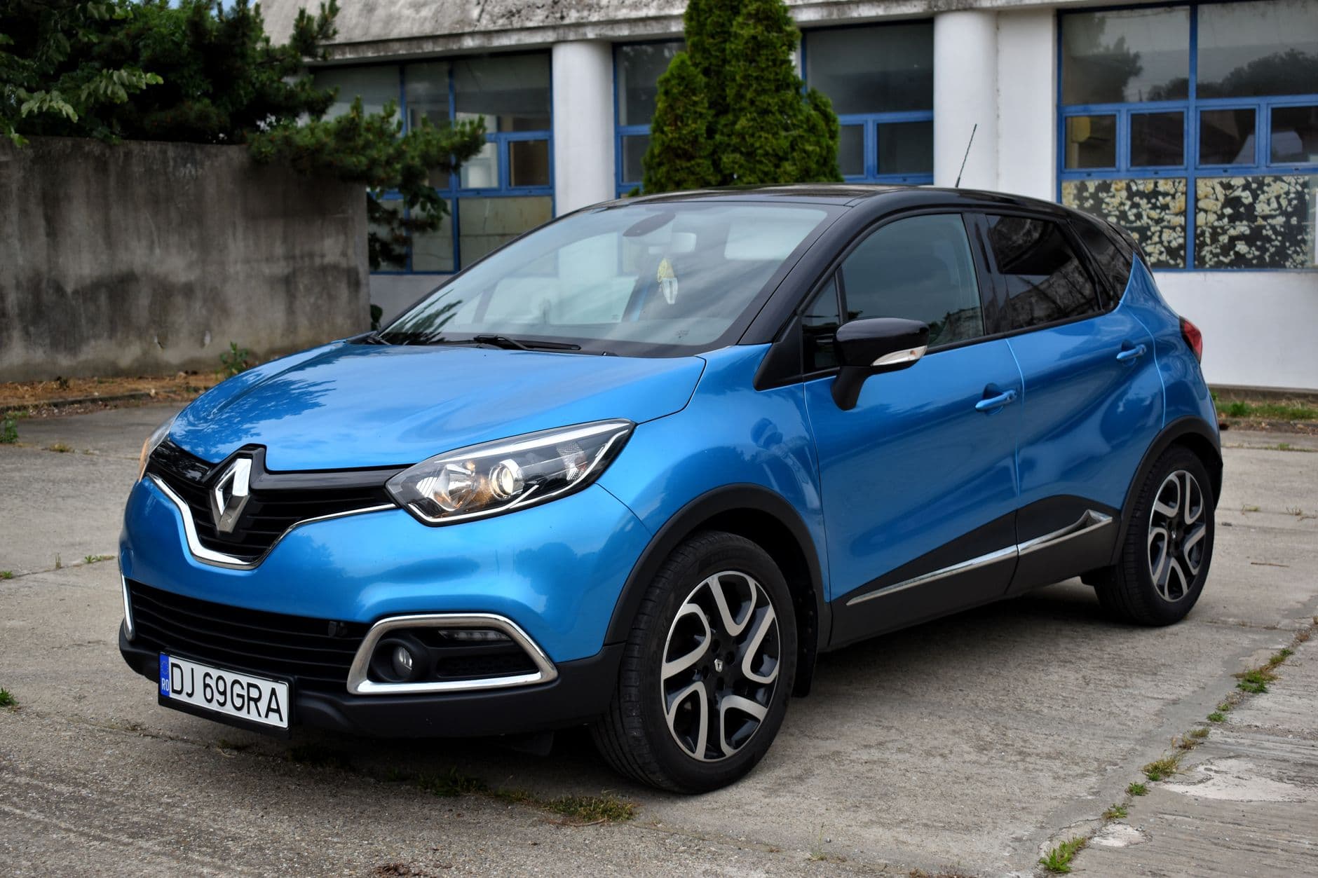 A blue Renault Captur parked in an urban outdoor setting, featuring modern design.